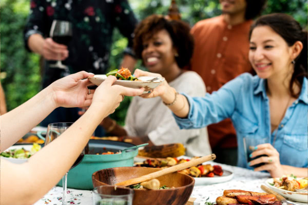Como calcular comida para festa: guia prático para eventos de todos os tipos 5 Pessoas compartilhando os alimentos em uma festa